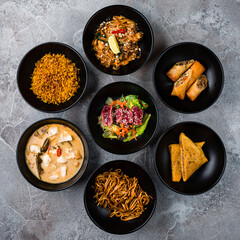 Rice noodle pad thai with chicken, rice with fried onions, Thai pancakes stuffed with meat, salad with beef, omelette stuffed with pork and corn soup with pork and noodles with onions. © smspsy