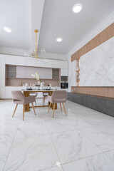 stylish kitchen and a set dining table in a light luxury interior design of a modern apartment in a minimalist style with marble trim and huge windows. daylight inside.