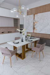 stylish kitchen and a set dining table in a light luxury interior design of a modern apartment in a minimalist style with marble trim and huge windows. daylight inside.