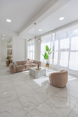 Fototapeta na wymiar light luxury interior design of a modern apartment in a minimalist style with marble trim and huge windows. daylight inside the kitchen and living room