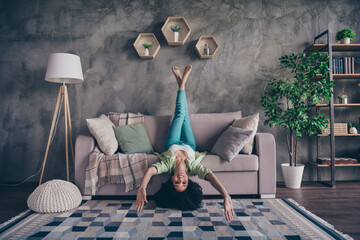 Full body length photo of upside down cadre funky young woman have fun lying grey sofa living room...