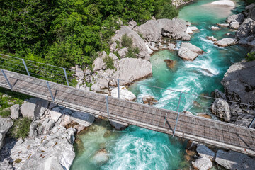 Suspension bridge in Soca valley over Soca river in Slovenia, top down drone view