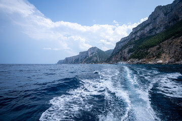 kamieniste i obrośnięte zieloną roślinnością zbocza wyspy Sardynia, widok z motorówki, fale © Arkadiusz