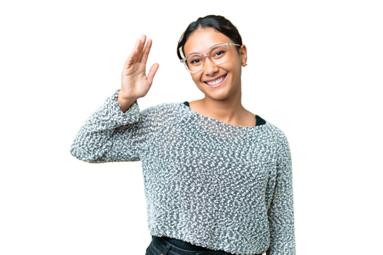 Young Uruguayan woman over isolated chroma key background saluting with hand with happy expression