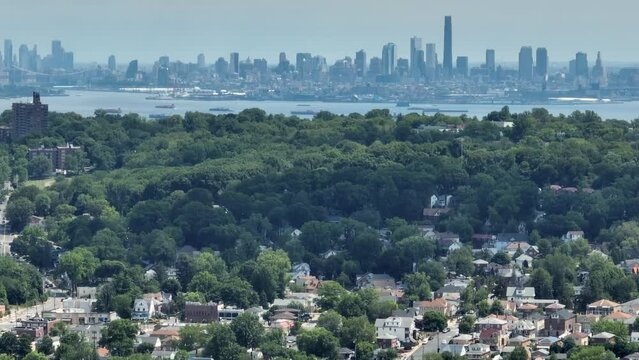 Panorama drone shot of Suburb District in Staten Island and enormous Skyline of Manhattan during foggy day in background - zoom lens aerial shot