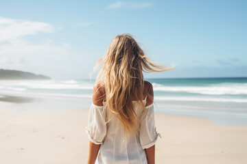 Fototapeta na wymiar The back view of a young stylish woman walking along a pristine sandy beach, her long blond hair flowing in the breeze Generative AI