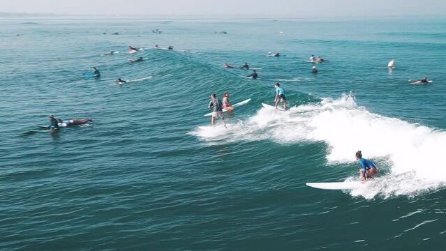 Crowd surfing, Bali. People surf the wave on famous Batu Bolong surfing spot on Bali, Indonesia