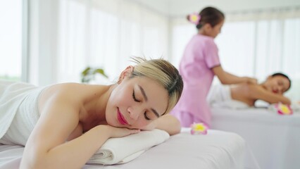 Obraz na płótnie Canvas Beautiful young asian woman lying on bed relaxing on holiday at spa salon. Woman sleep on spa bed resting after body massage in spa resort. Spa treatment, body relaxation concept