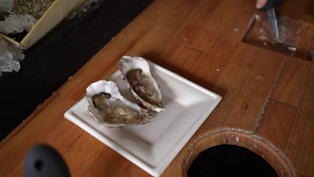 Serving oyster at a food truck onto a paper tray