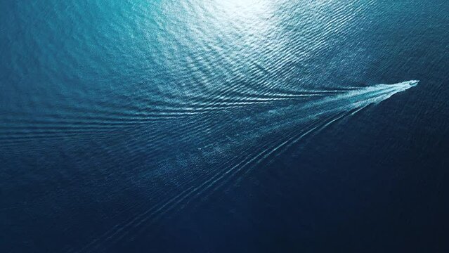 Fast boat moves in the tropical sea. Camera follows and ascends