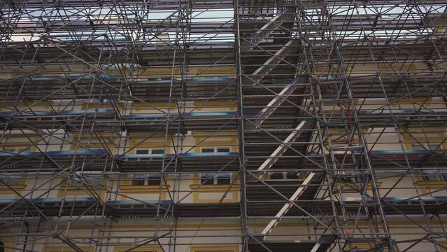 Scaffolding on old building in Europe, restored historic building, details of facade. Restoration industry, old architecture, real estate renovation, no people. scaffolding building under construction