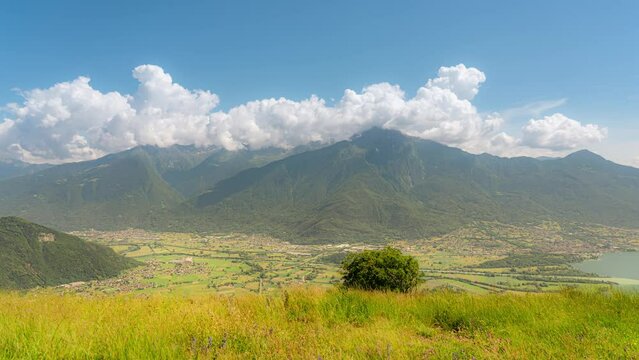 View of the green mountains with fluffy clouds flowing above
