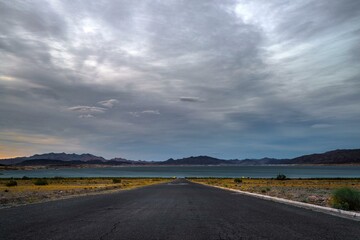 Desert Serenity: Panoramic View of an Empty Road Surrounded by Red Rock Canyon After a Storm, Presented in Captivating 4K Resolution