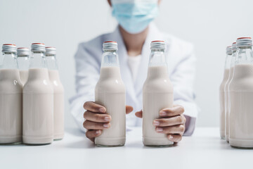 Quality control laboratory dairy factory professional people checking milk bottles quality, Dairy factory industry products.