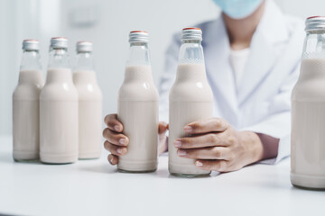 Quality control laboratory dairy factory professional people checking milk bottles quality, Dairy factory industry products.