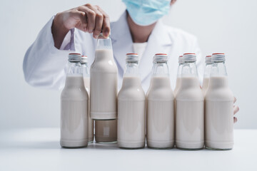 Quality control laboratory dairy factory professional people checking milk bottles quality, Dairy factory industry products.