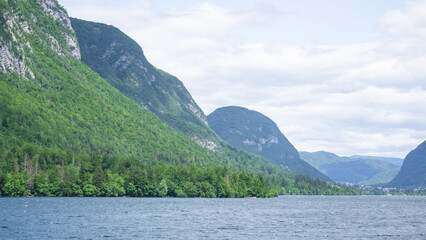Fototapeta premium Beautiful panorama of a lake with green mountains on a cloudy day