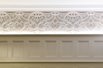 A decorative wooden white antique mosaic molding. The carving is circular scrolls with layers and...