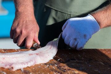 Fresh codfish out of the Atlantic Ocean filleted and cleaned on a wooden table. The chef prepares...