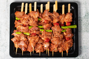 Chicken skewer. Chicken skewers with raw sauce on gray background. Top view