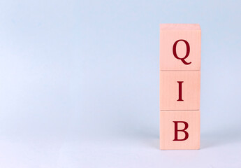 QIB on wooden cubes on a blue background