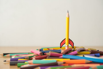 Yellow pencil rocket ship form launch with white background copy space. Education, learning,...