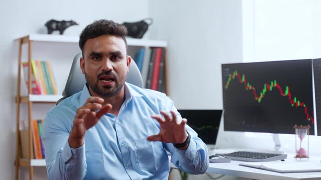 Confident indian trader or stock broker explaining about stock market by looking camera at office - concept of Investment Strategies, trading tips and financial Expert