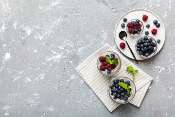 Healthy breakfast or morning with chia seeds vanilla pudding raspberry and blueberry berries on table background, vegetarian food, diet and health concept. Chia pudding with raspberry and blueberry