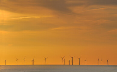 Panorama of Offshore Wind Turbines in the North Sea, generating electricity, at sunset near Scheveningen,The Netherlands