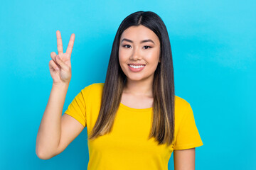 Portrait of attractive asian girl meet friends say hi show v sign gesture wear yellow t-shirt...