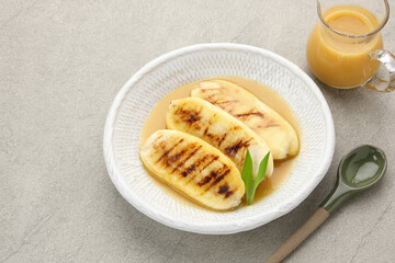 Pisang Gapit or Pisang Epe, grilled banana with palm sugar sauce. Indonesian traditional food.
