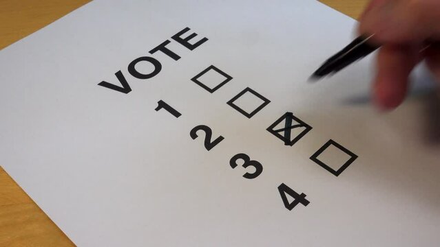 Voting Paper. Taking a vote making a choice. Putting a cross in a box on a voting paper.