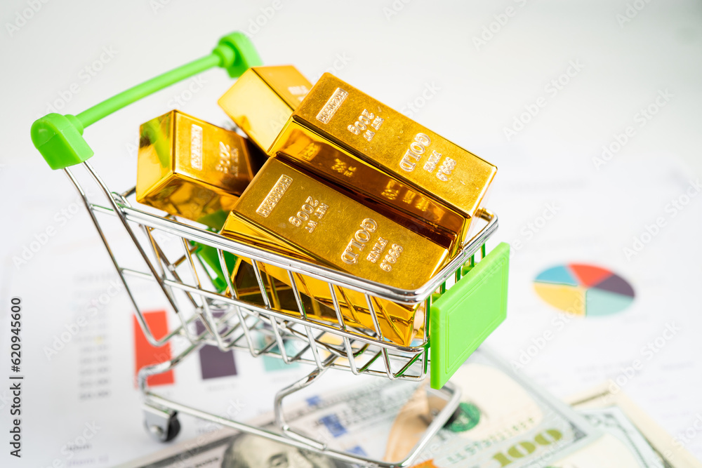 Wall mural gold bar in shopping cart on us dollar banknotes money and graph, economy finance exchange trade inv