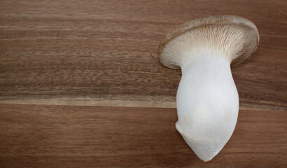 Background with king brown mushroom on brown kitchen board