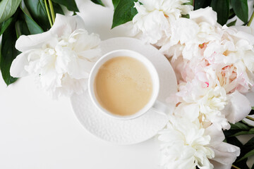 Top view of morning romantic coffee cup, white peonies flowers