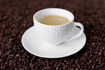 Ceramic cup of dark coffee on background from coffee beans