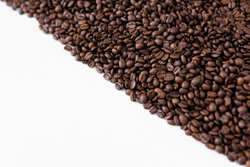 Roasted black coffee beans on white background with copyspace