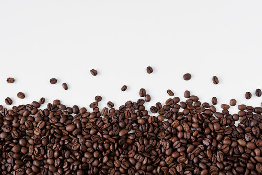 Roasted black coffee beans on white background with copy space © Di Studio