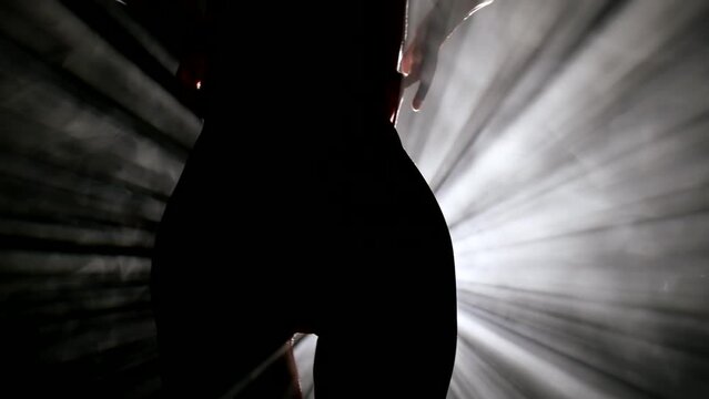 elegant sexy body of slender woman, silhouette of hips in darkness, lady dancing in dark room