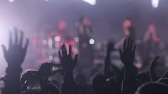 People dancing with raised arms during performance