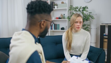 Obraz premium Young woman feeling distraught during appointment with a psychologist, domestic violence victim