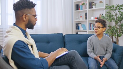 Pre-teen boy talking to school psychologist, adolescent counseling services