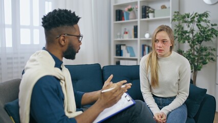Male doctor talking to female patient, therapy for domestic violence victims and people battling depression