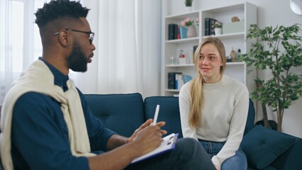 African American male psychiatrist encouraging woman domestic violence survivor who's feeling better after treatment