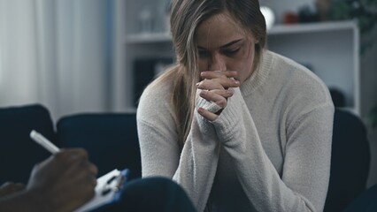 Unhappy young woman with injured face crying at therapy session, depression