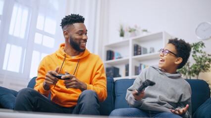 Happy brothers having fun playing video games at home, leisure time, gaming hobby