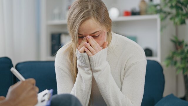 Young woman domestic violence victim crying at therapy session, in need of emotional support
