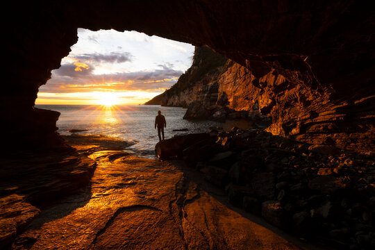 A boy admires a beautiful spring sunset from the Byron cave, Portovenere, La Spezia province, Liguria district