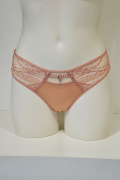 Lingerie. Women's beige lace panties on a mannequin, on a white background.
