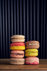 stack of macaron cookies on wooden table and dark background